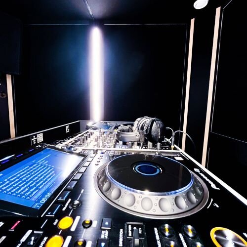 DJ studio with Pioneer CDJ-3000 turntables, mixer and headphones