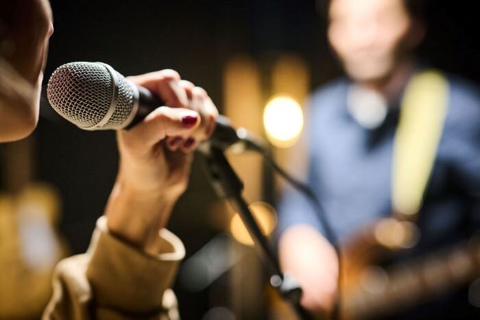 Singer in rehearsal studio with guitarist