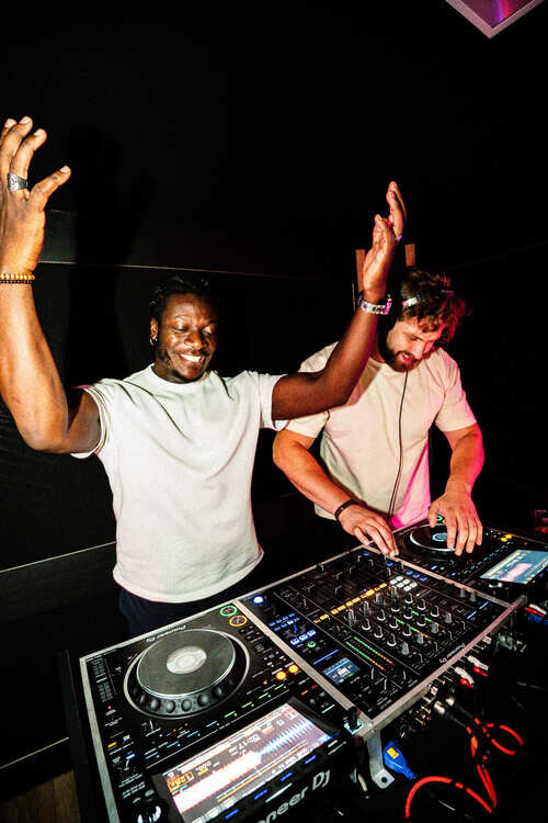 Two DJ friends mixing together in a DJ studio