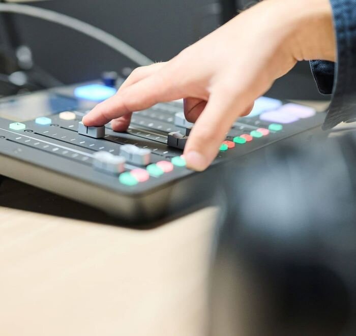 Man adjusting the Rodecaster Pro to record a podcast