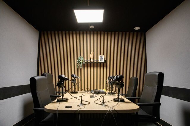 Podcast studio equipped with mixer, microphones, customizable lighting and vintage decor