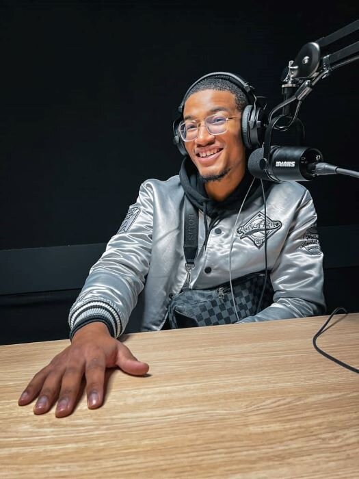 Smiling podcaster with headphones and microphone, ready to record a podcast