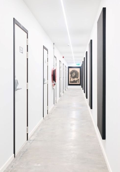 Music studio corridor with white walls and doors and black acoustic panels