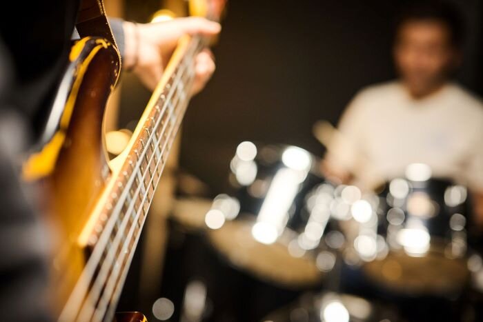 Bassist and drummer playing in a rehearsal studio 