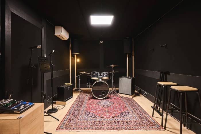 Studio de répétition avec batterie, table de mixage et amplis