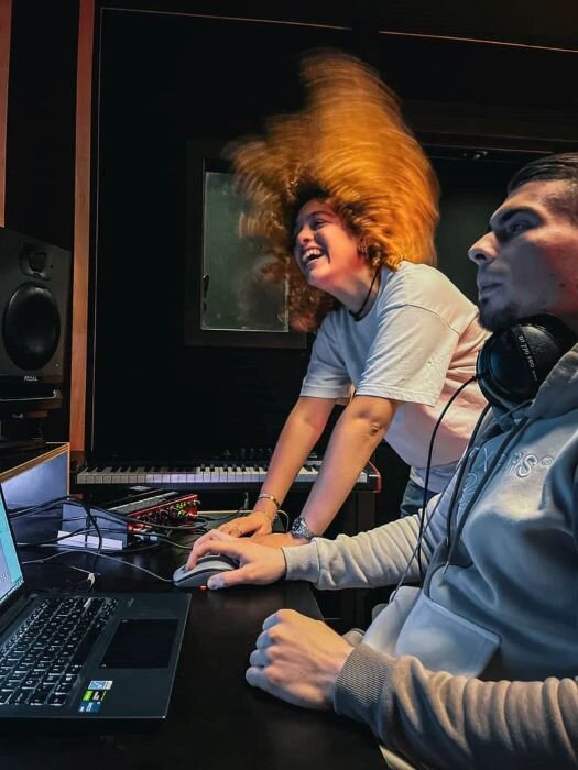 Beatmaker et femme souriante dans studio de production