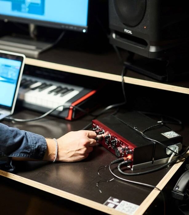 Homme utilisant une carte son Focusrite Clarett 4Pre+ dans un studio d'enregistrement