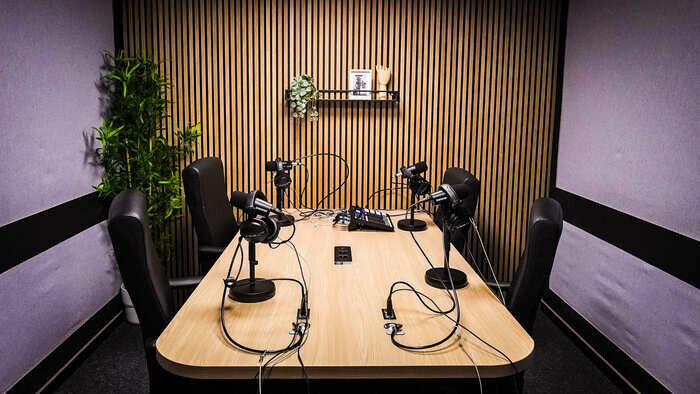 Podcaststudio uitgerust met microfoons, mengpaneel, verlichting en vintage decor