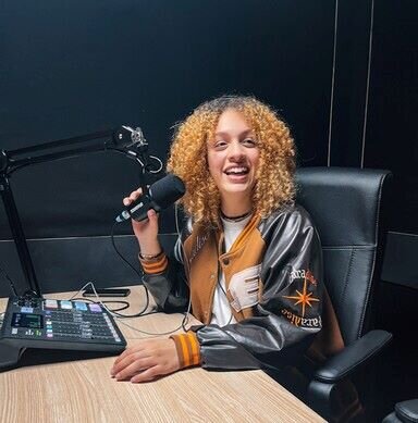 Vrouw in podcaststudio voor een microfoon en een Rodecaster Pro