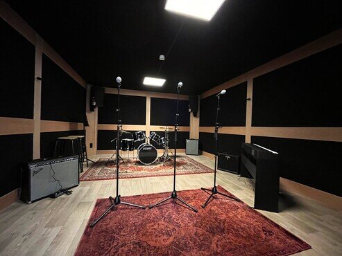 Repetitiestudio uitgerust met microfoons, keyboard, versterkers en drums 