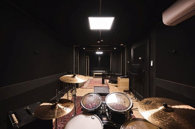 Rehearsal room with drum set, amps, and mixing board. | © Plug The Jack