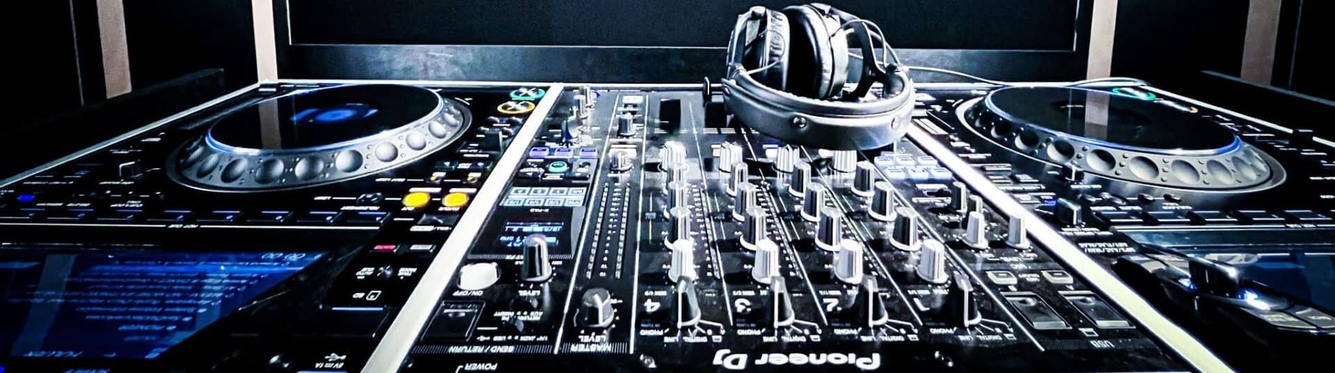 DJM-900NX2-mengpaneel, CDJ-3000-spelers in DJ-repetitiestudio met koptelefoon. | © Plug The Jack